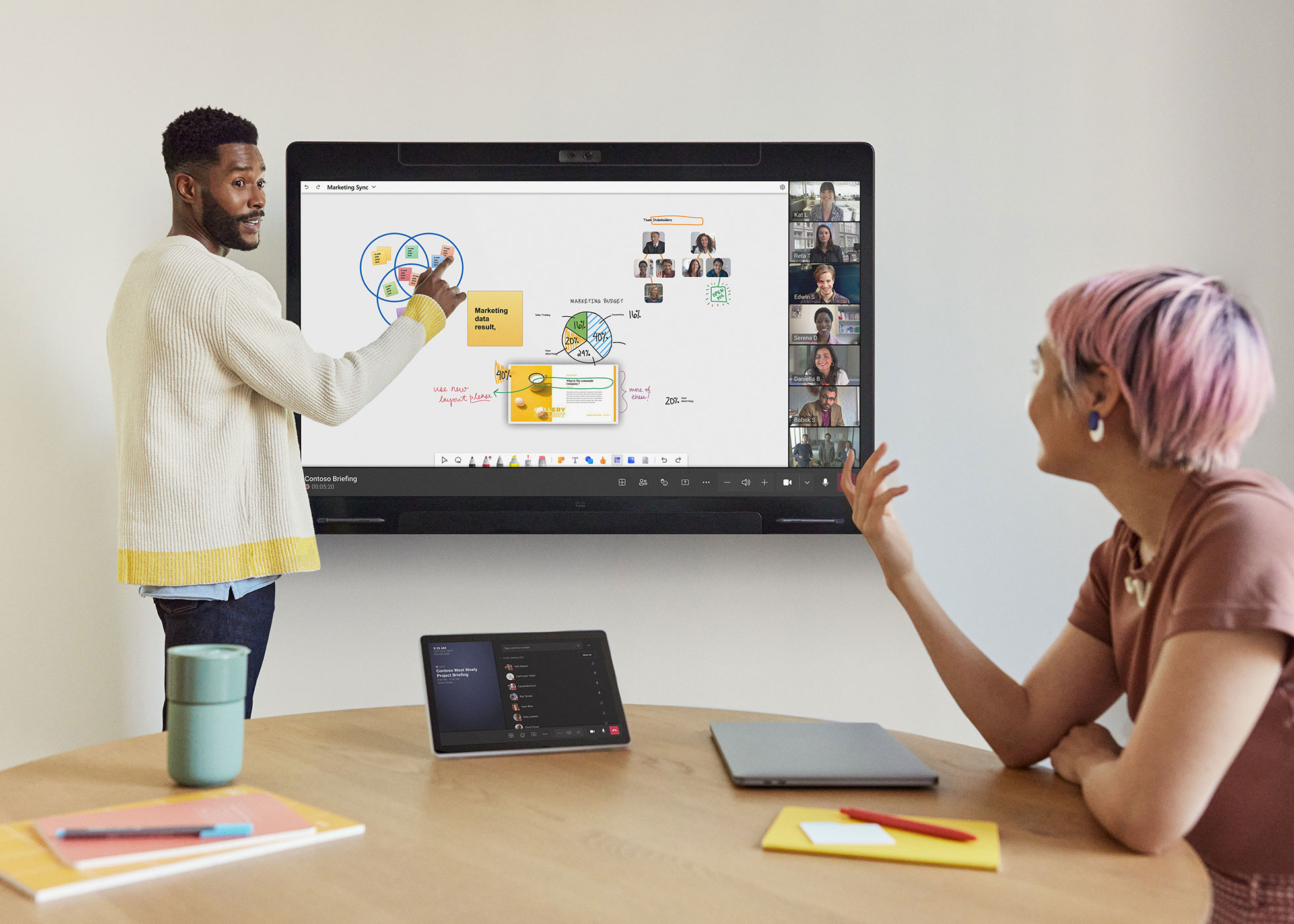 Two colleagues in the office collaborate with remote participants on Microsoft Teams using a Cisco Board Pro.