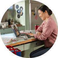 Person takes a video meeting from the kitchen while working at home via Webex Meetings on a laptop.